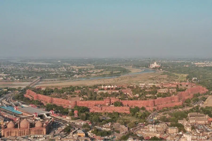 aerial view of agra fort with yamuna river and taj mahal in the distance