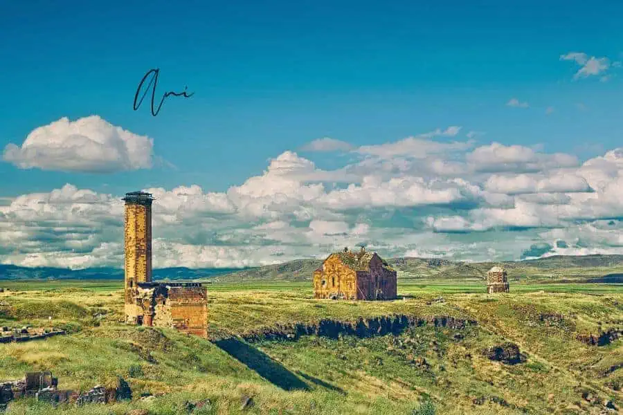 ancient ruins of ani, turkey with green fields and a bright blue sky