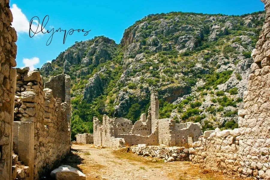 ruins of olympos with rocky mountains in the background