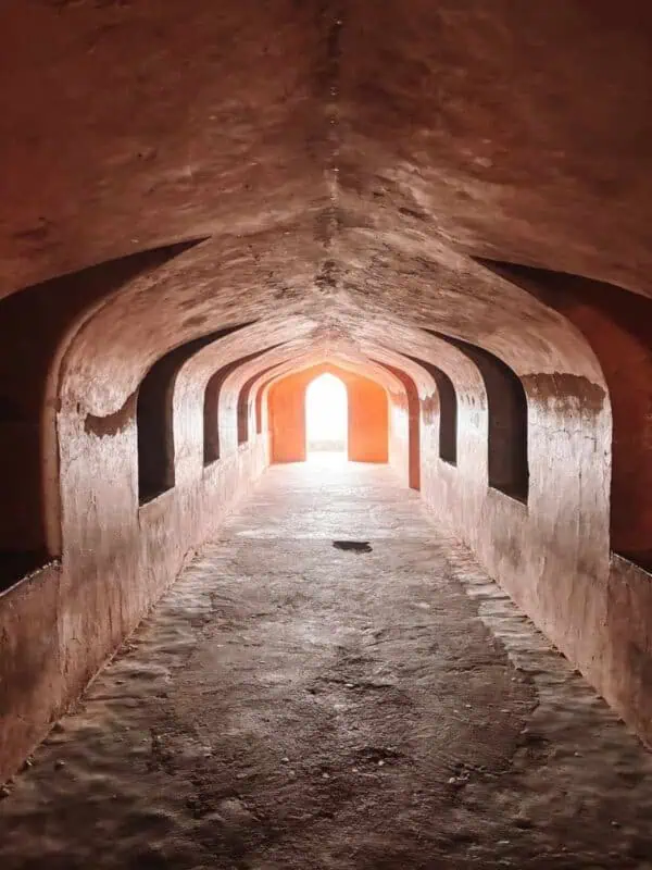 arched tunnel inside bhulbhulaiya with light at the end, bara imambara, lucknow