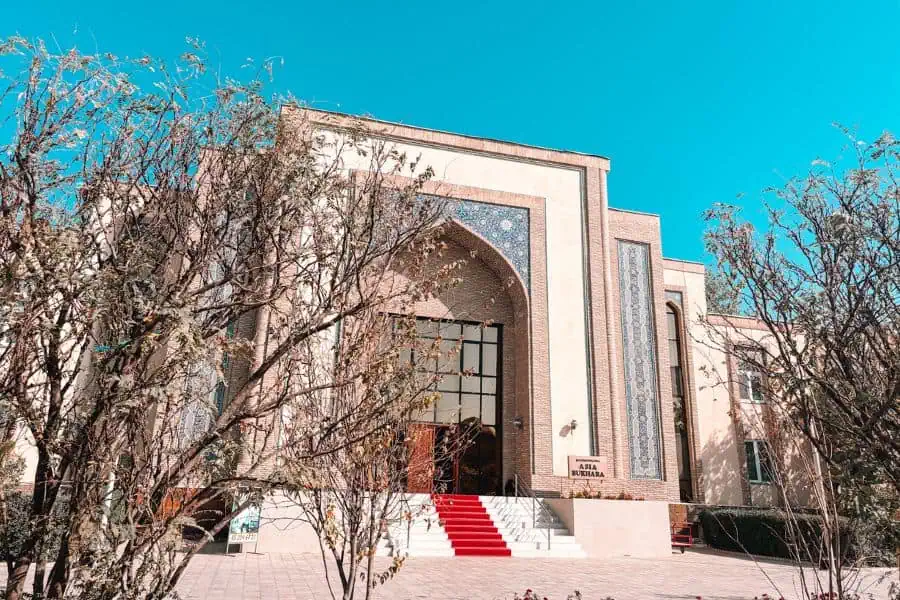 asia bukhara hotel exterior with traditional uzbek architecture, arched entrance, and red carpet steps