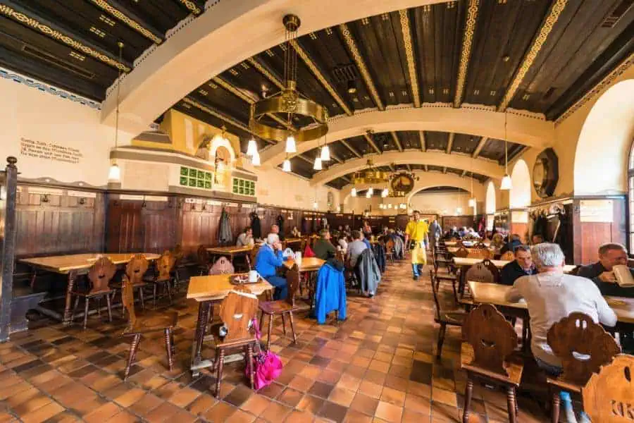 people enjoying authentic local beer in a large hall at augustiner brau kloster mulln brewery salzburg