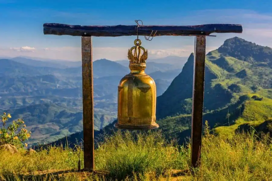 golden bell at doi pha tang viewpoint in chiang rai in thailand with a scenic mountain landscape in the background