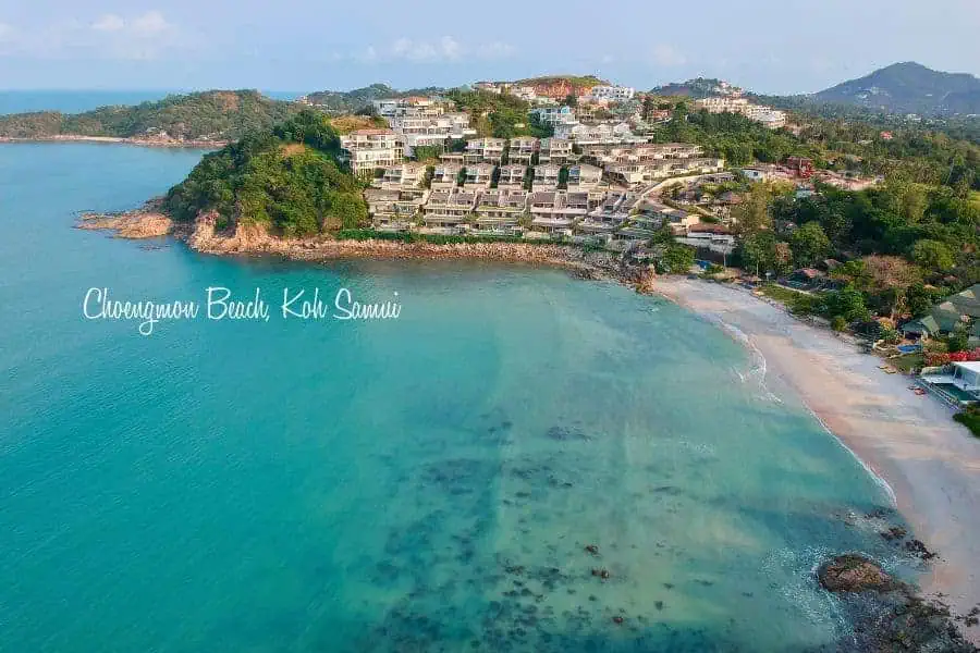  aerial view of choengmon beach in koh samui, thailand, featuring turquoise waters, white sandy shores, and luxury hillside resorts surrounded by lush greenery