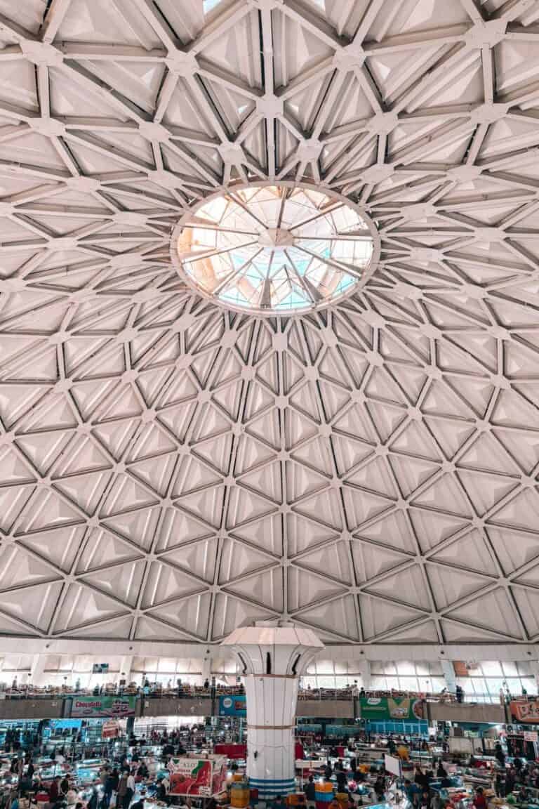 inside view of chorsu bazaar in tashkent, showing the massive domed ceiling with geometric patterns and the bustling market below filled with vendors and shoppers