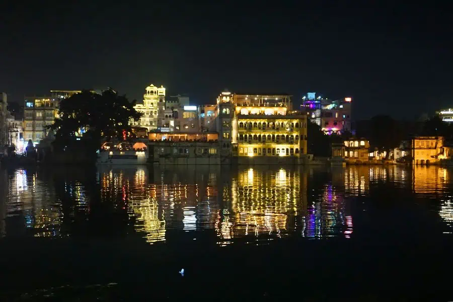 city lights shimmering in the waters of lake pichola udaipur at night