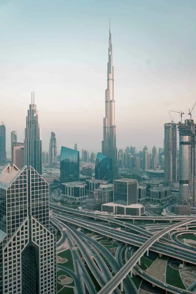 aerial view of Dubai skyline with Burj Khalifa towering above the city and curving highways below