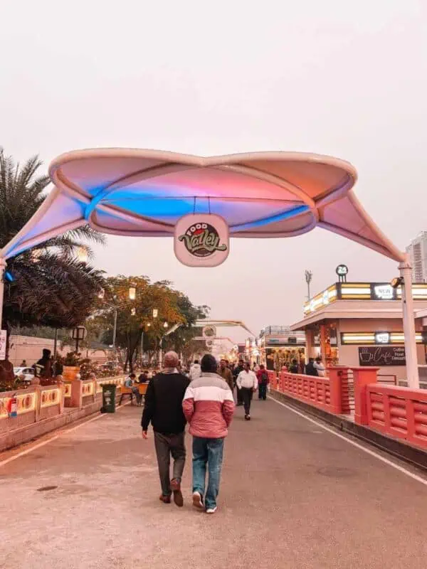 food valley walkway at gomti riverfront with lit canopy and people strolling, lucknow