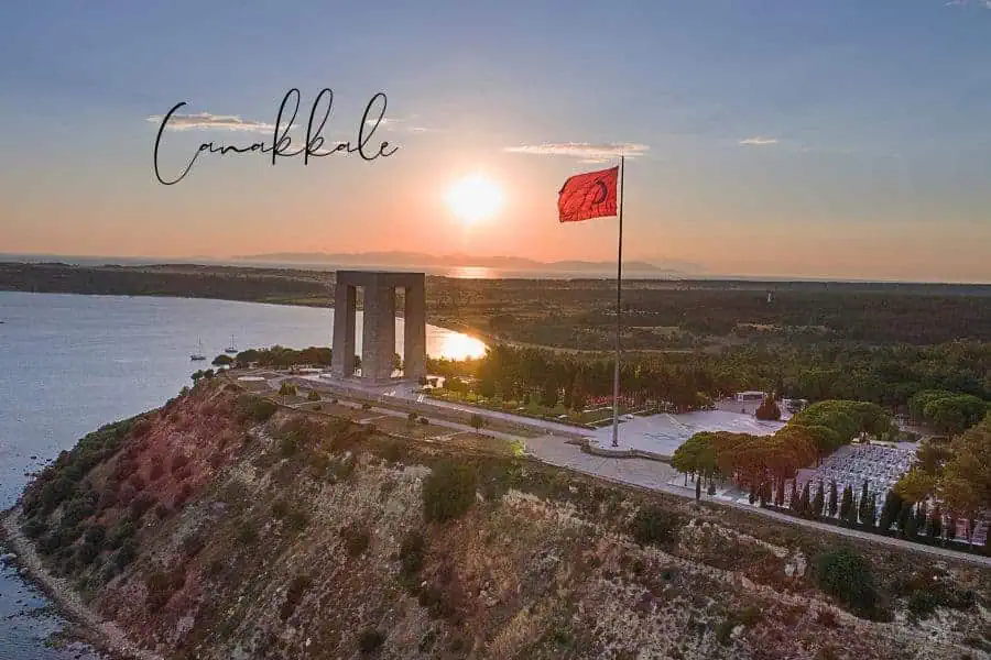 the gallipoli monument in çanakkale standing tall with a turkish flag at sunset