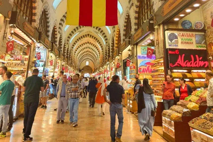 people shopping inside the bustling grand bazaar in beyazit neighborhood of istanbul surrounded by colorful shops and goods