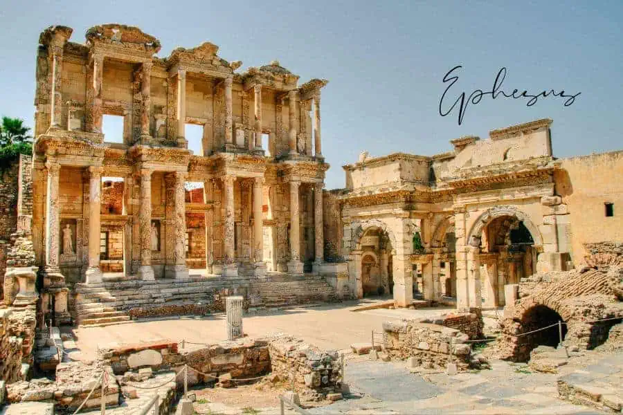 the ancient ruins of the library of celsus in ephesus, with its grand columns and intricate carvings standing against a clear sky