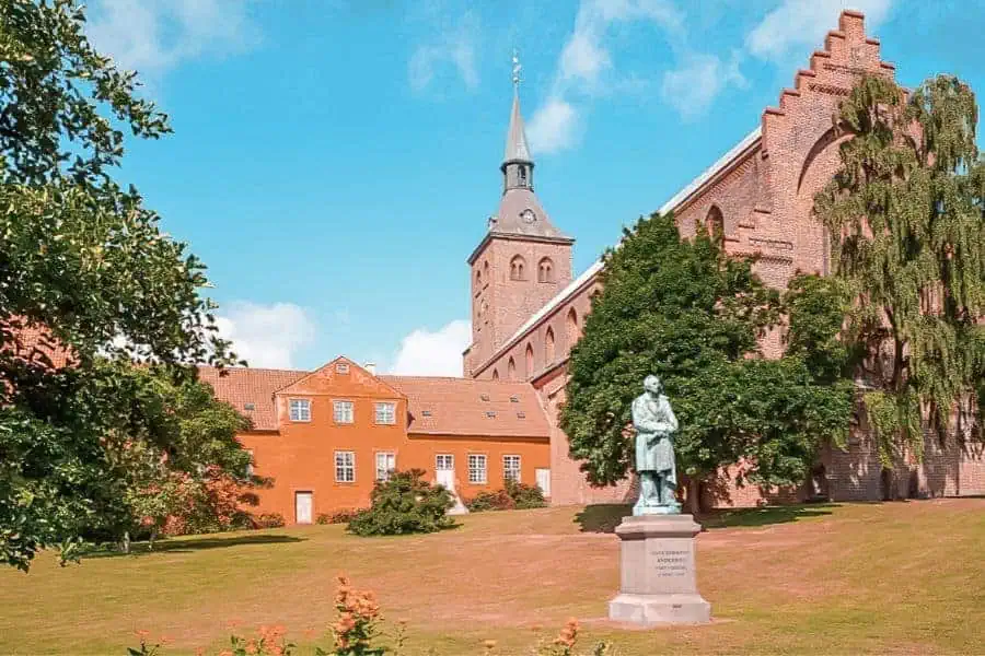 The Hans Christian Andersen statue standing in the sun-drenched garden outside St Canute's Cathedral in Odense, Denmark, birthplace of the world's most famous fairytale writer