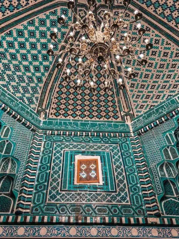 ornate chandelier hanging beneath tiled dome of the kusum ibn abbas mausoleum at shah i zinda samarkand
