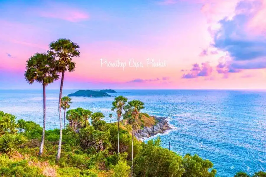 breathtaking sunset view at promthep cape in phuket, thailand, with tall palm trees, lush greenery, and the vast ocean stretching to the horizon