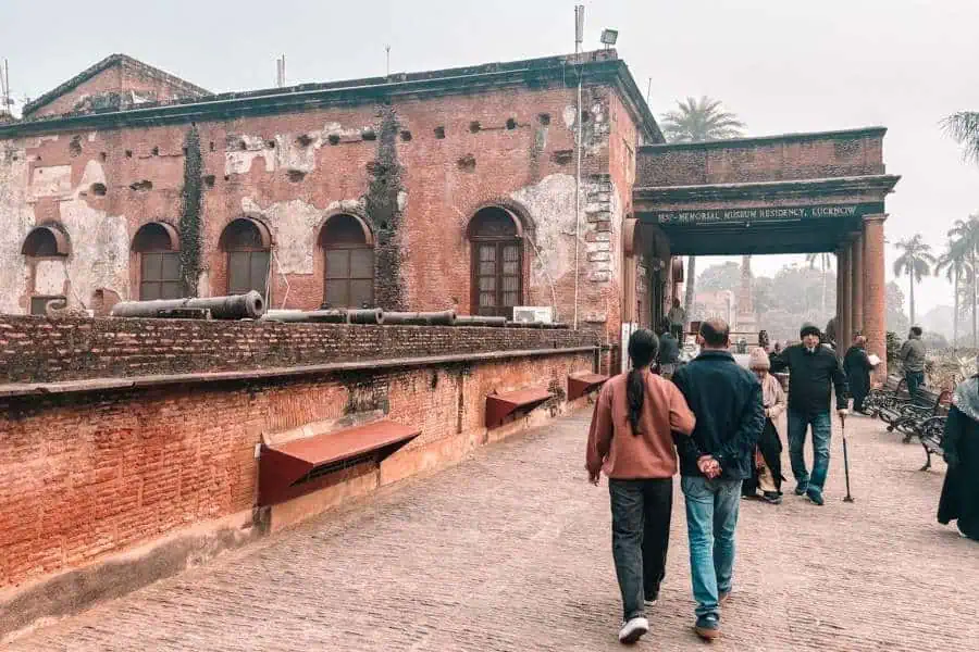 exterior walkway of the residency museum with old brick walls and cannons, lucknow