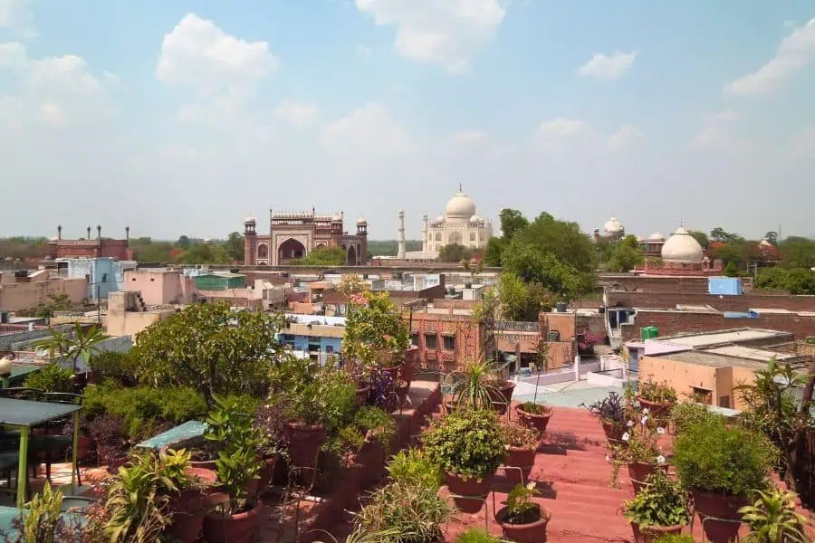 rooftop view of agra city with taj mahal and mughal monuments in the distance
