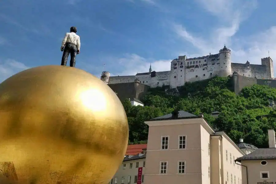 sculpture sphaera at kapitelplatz aka the chapter square in salzburg with towering hohensalzburg fortress in the backdrop