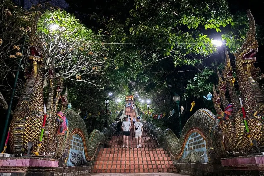 people climbing up and down the steps leading to doi suthep in chiang mai