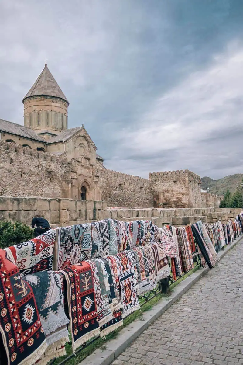 colorful georgian carpets displayed outside svetitskhoveli cathedral in mtskheta