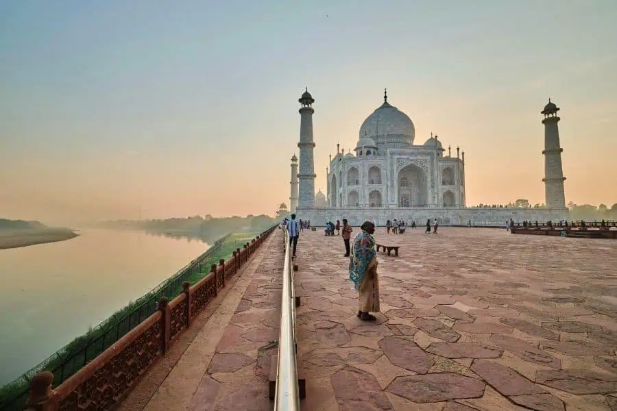 taj mahal view from riverside platform with early morning visitors