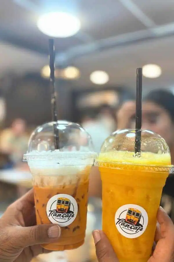 the glasses of thai tea and mango juice at maeklong railway station in bangkok thailand