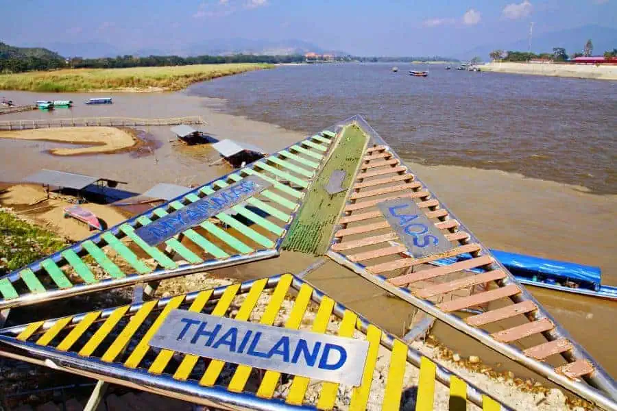 view of the golden triangle near chiang rai, where the borders of thailand, laos, and myanmar meet...the photo shows the mekong river with a sign highlighting each country