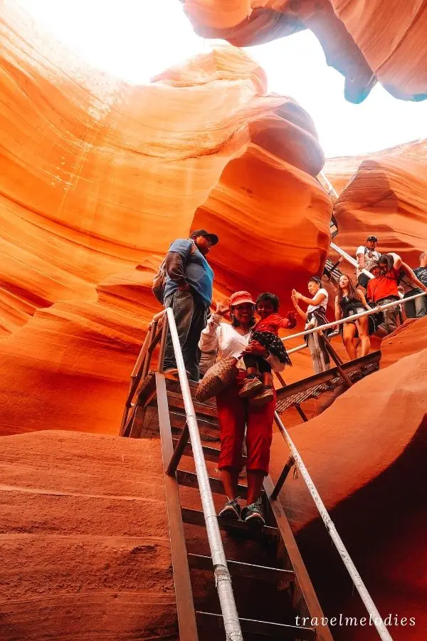 descending a steep metal staircase into lower antelope canyon with kids