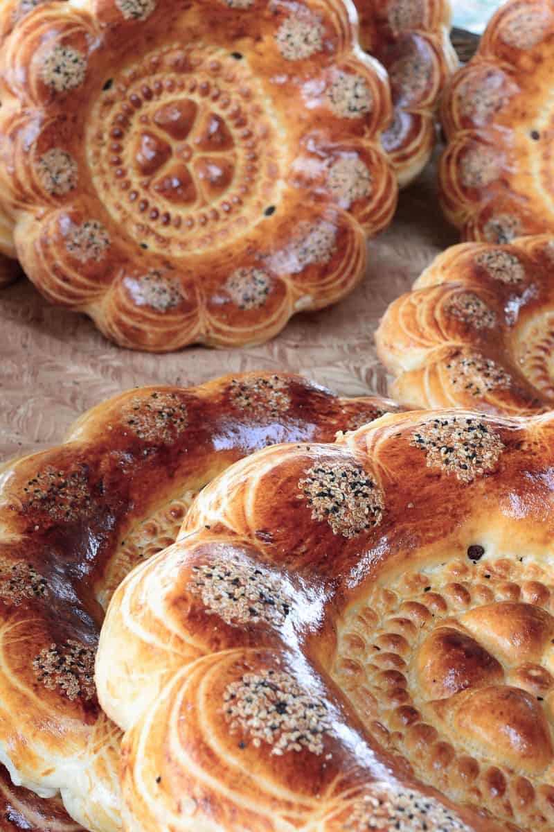 close-up of freshly baked traditional uzbek bread non with golden crust and sesame seeds